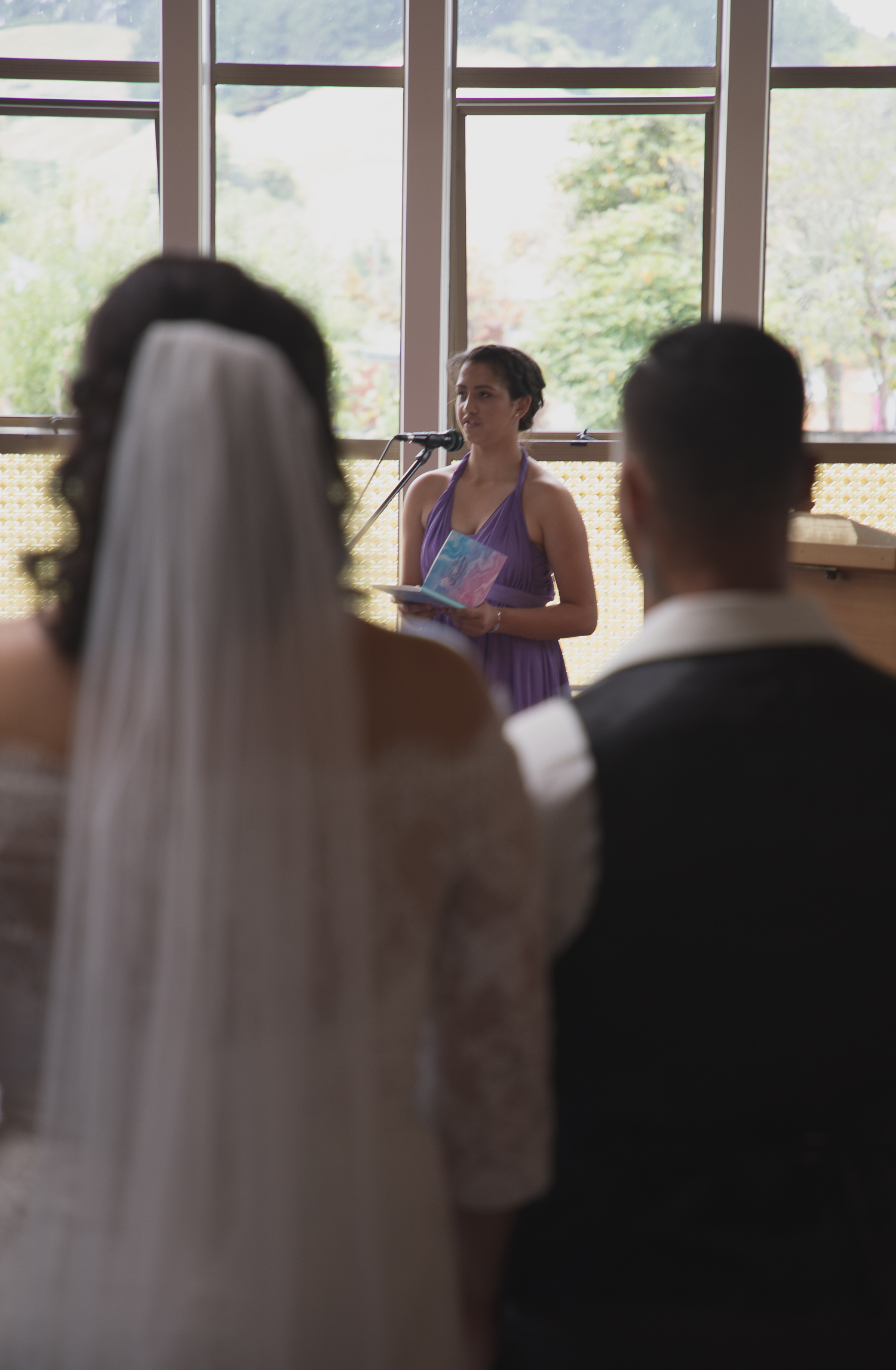 bridesmaid singing as bride and groom watch on