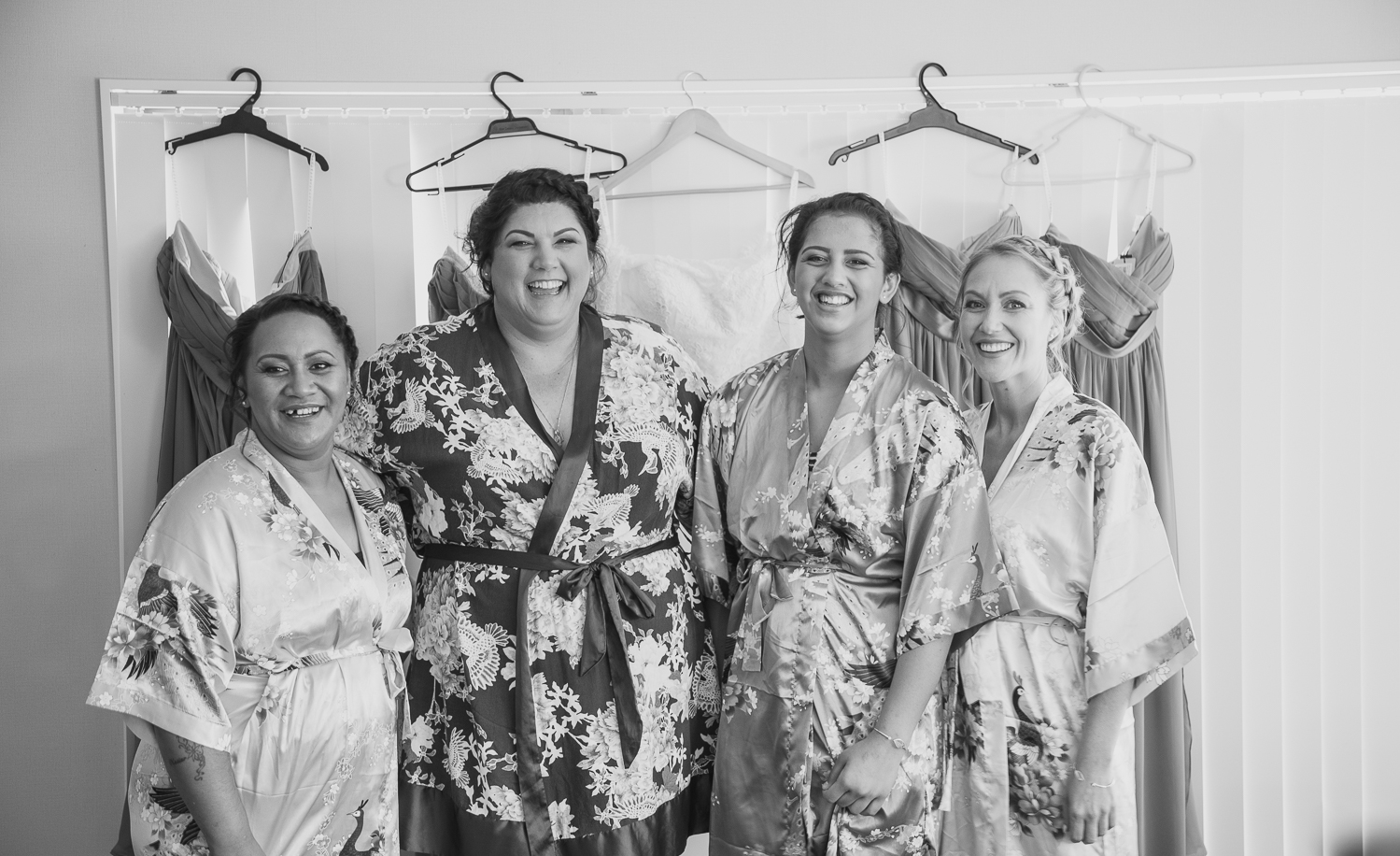 bridesmaids in front of wedding dresses