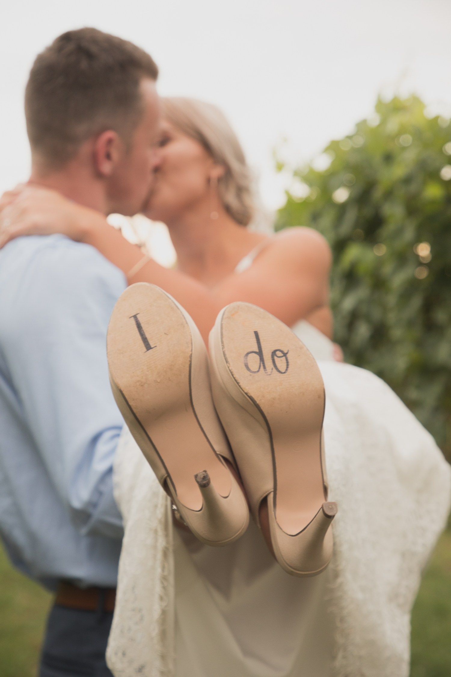 groom lifitng bride up shoes saying i do