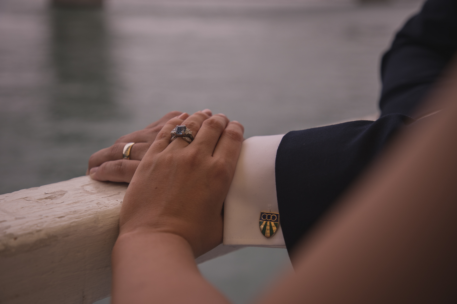 bride and groom together under Auckland Harbour Bridge with rings showing