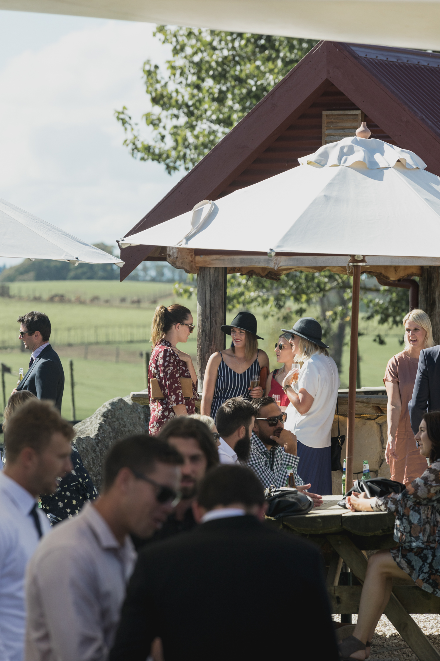 wedding-at-the-red-barn-new-zealand-wedding-photographer-guests-under-umbrellas.jpg