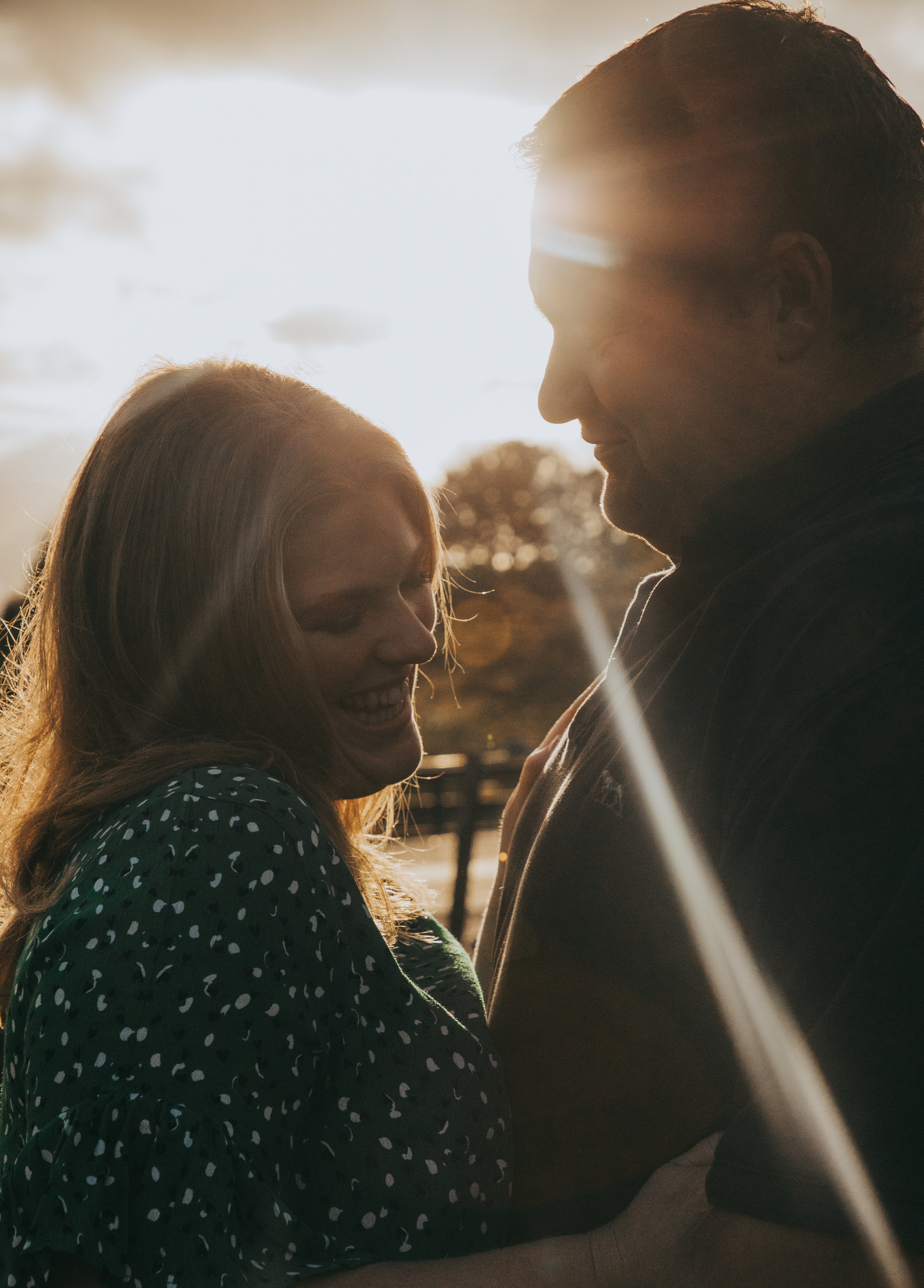 waikato-wedding-photographer-couple-on-their-farm-laughing-together-in-autumn-colours-on-leaves