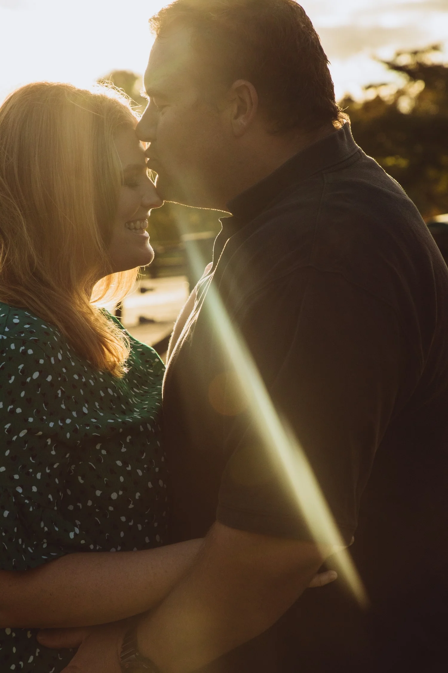 waikato-wedding-photographer-couple-on-their-farm-laughing-together-in-autumn-colours-on-leaves