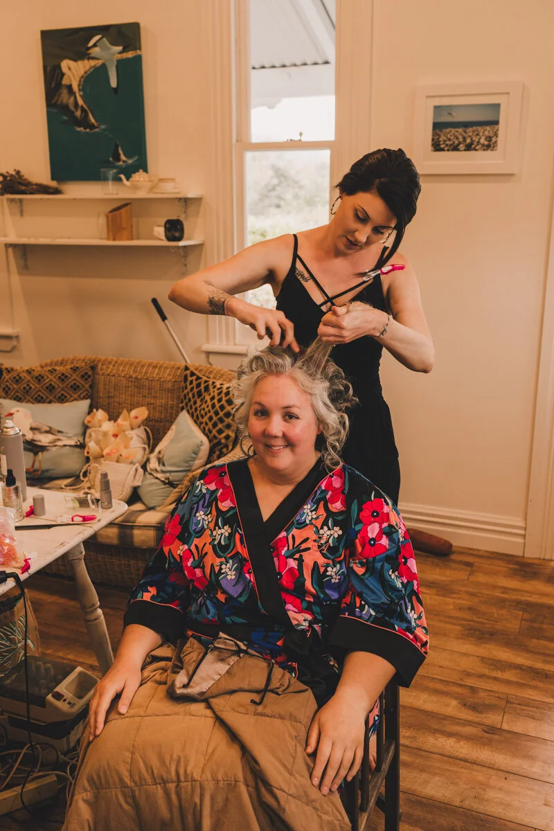 bride getting hair done on wedding day