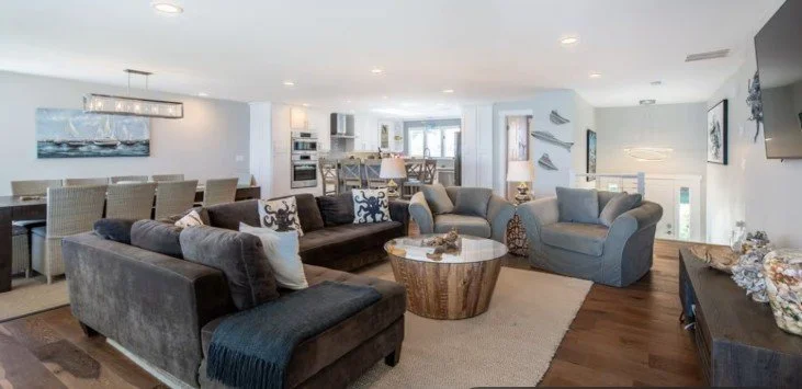 Bright open-concept living room with harbor views at Obstreperous Octopus waterfront rental