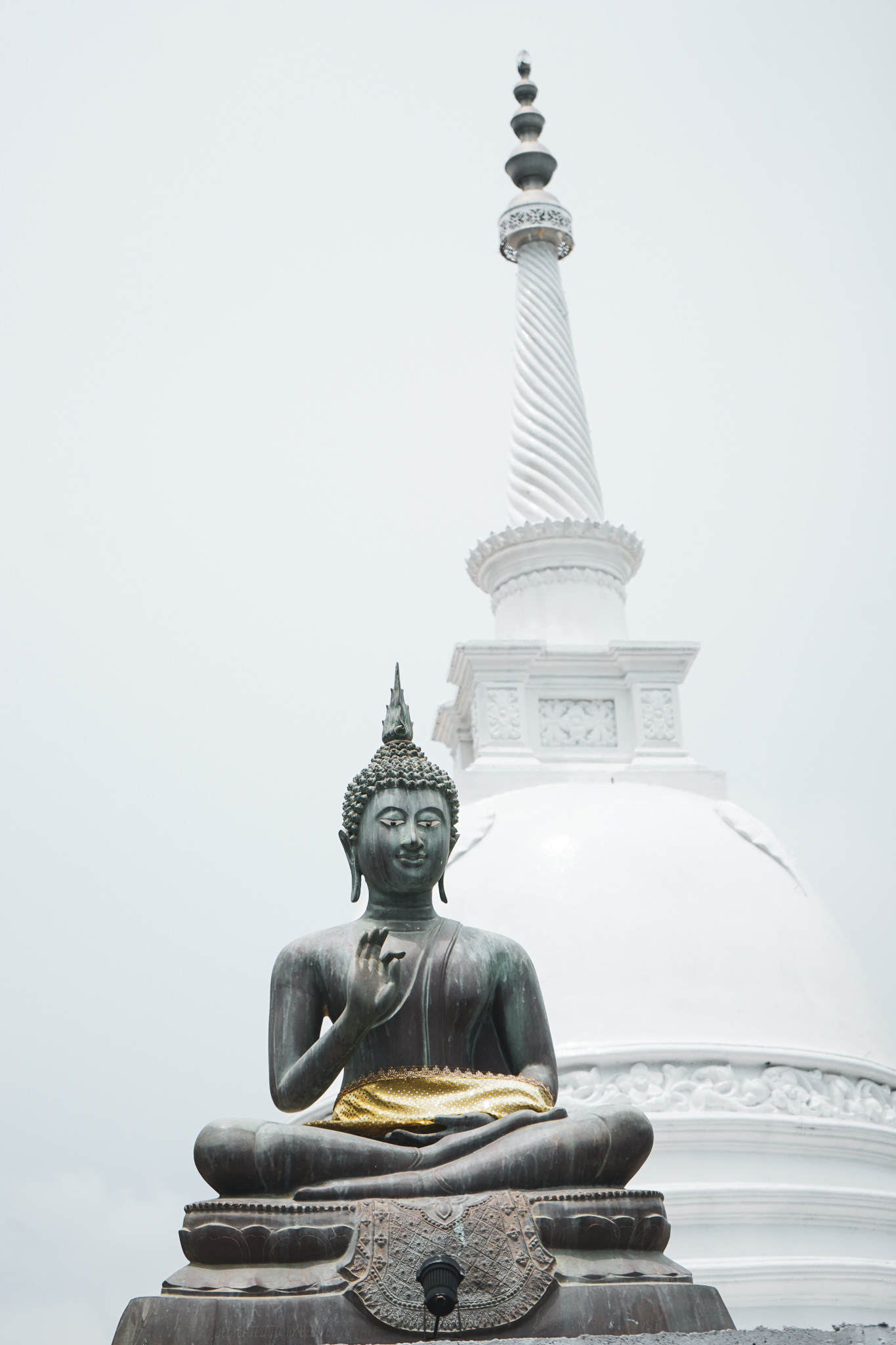 Stupa and bronze Buddha in yoga pose
