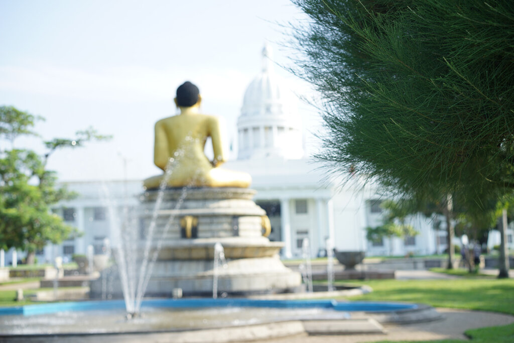 Buddha statue at Viharamahadevi Park overlooking to Town Hall