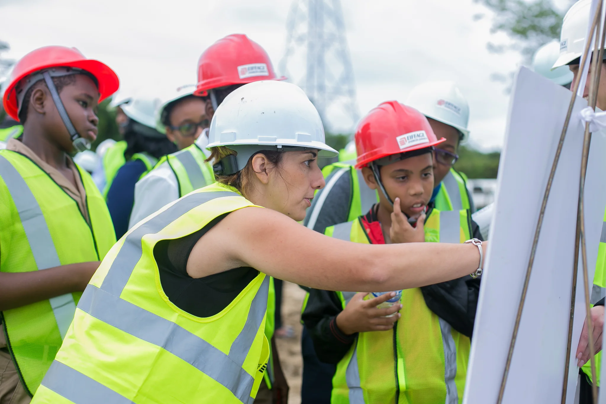 Winners of the Project Shine competition held at neighbouring high schools attend the ground breaking ceremony. They are provided with an overview of the project by a representative from Eiffage Energia.