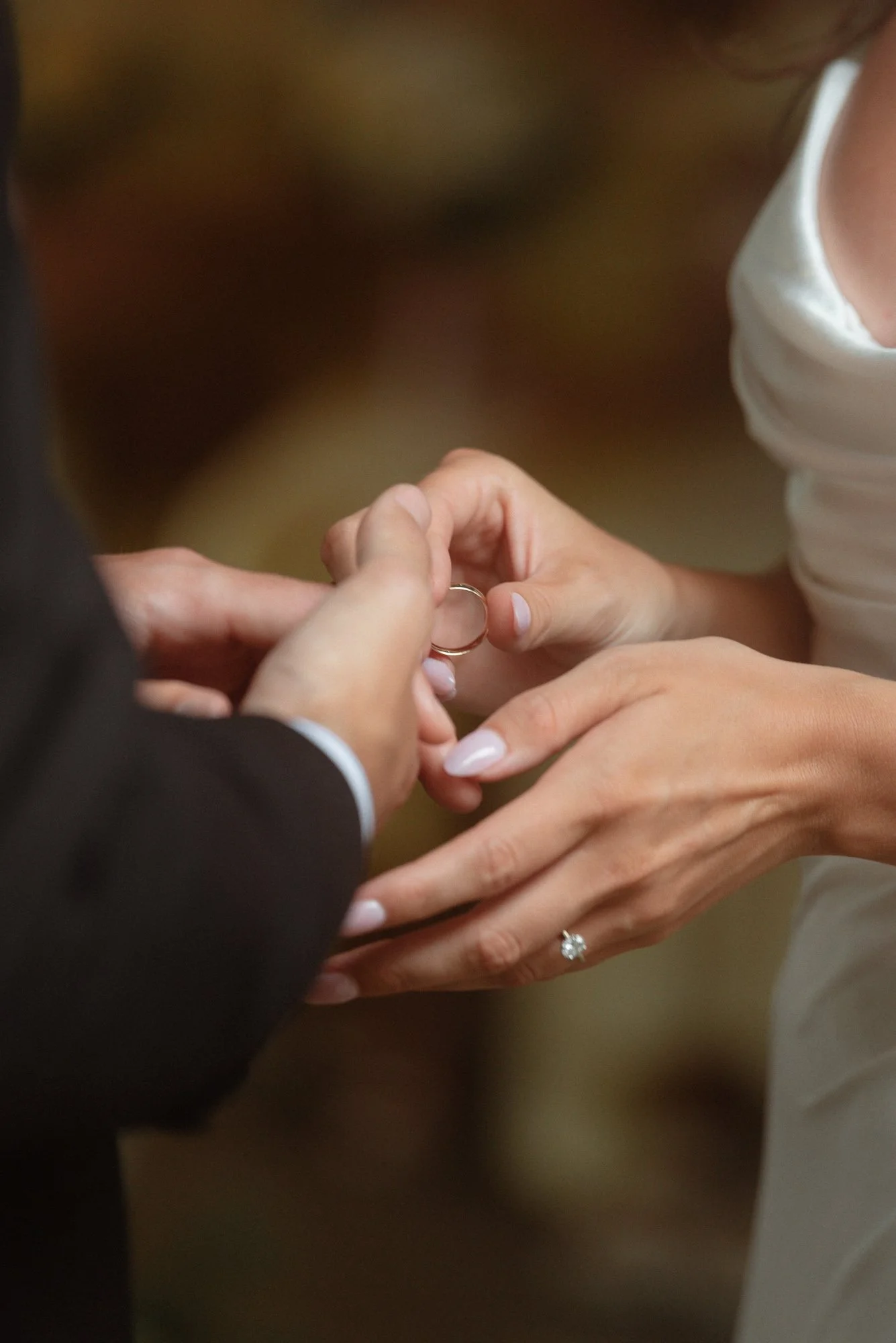 Close-up of wedding ring exchange at Farm at South Cove Nova Scotia with soft bokeh background