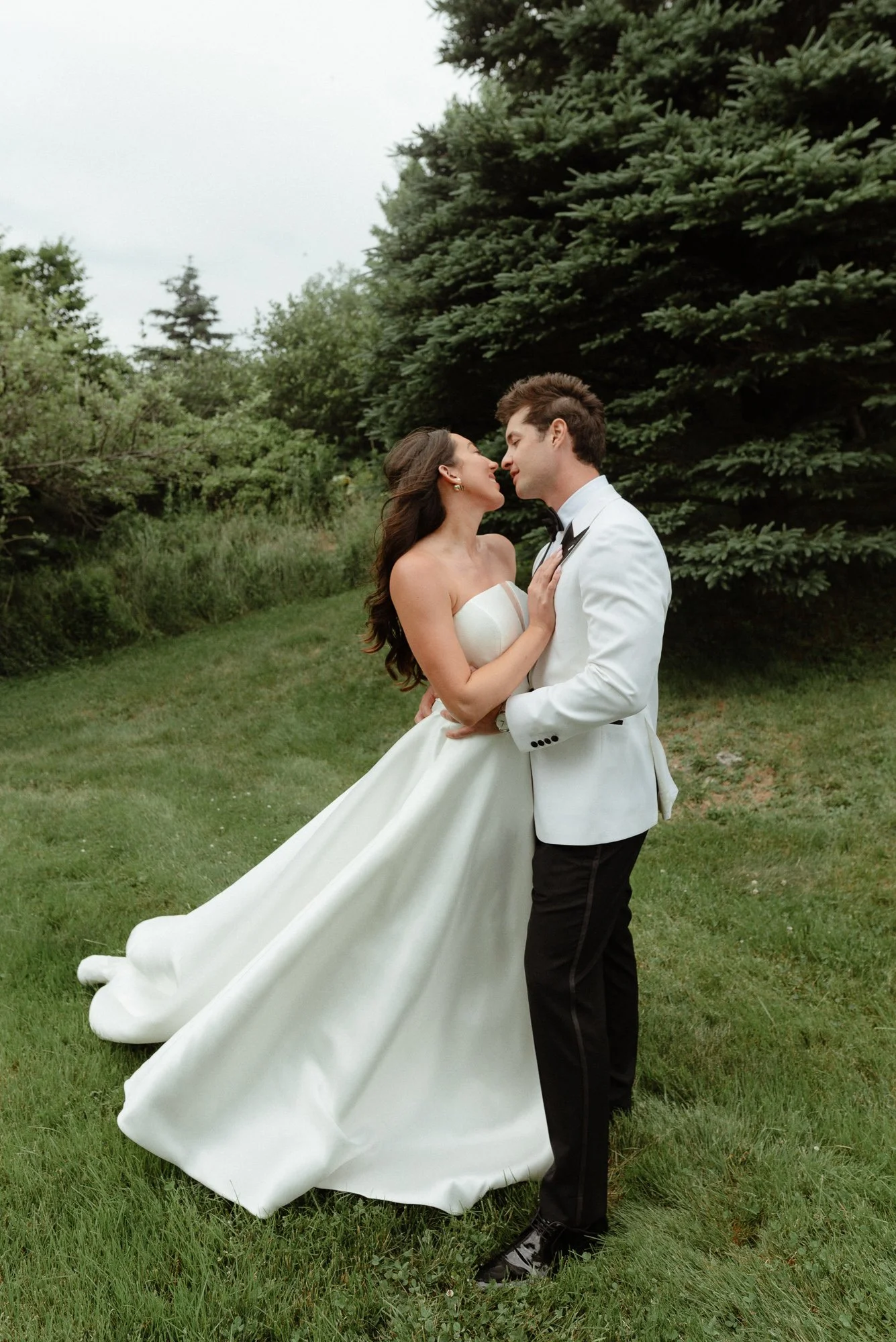 Bride and groom about to kiss in lush field at Harbour Mist Nova Scotia wedding venue
