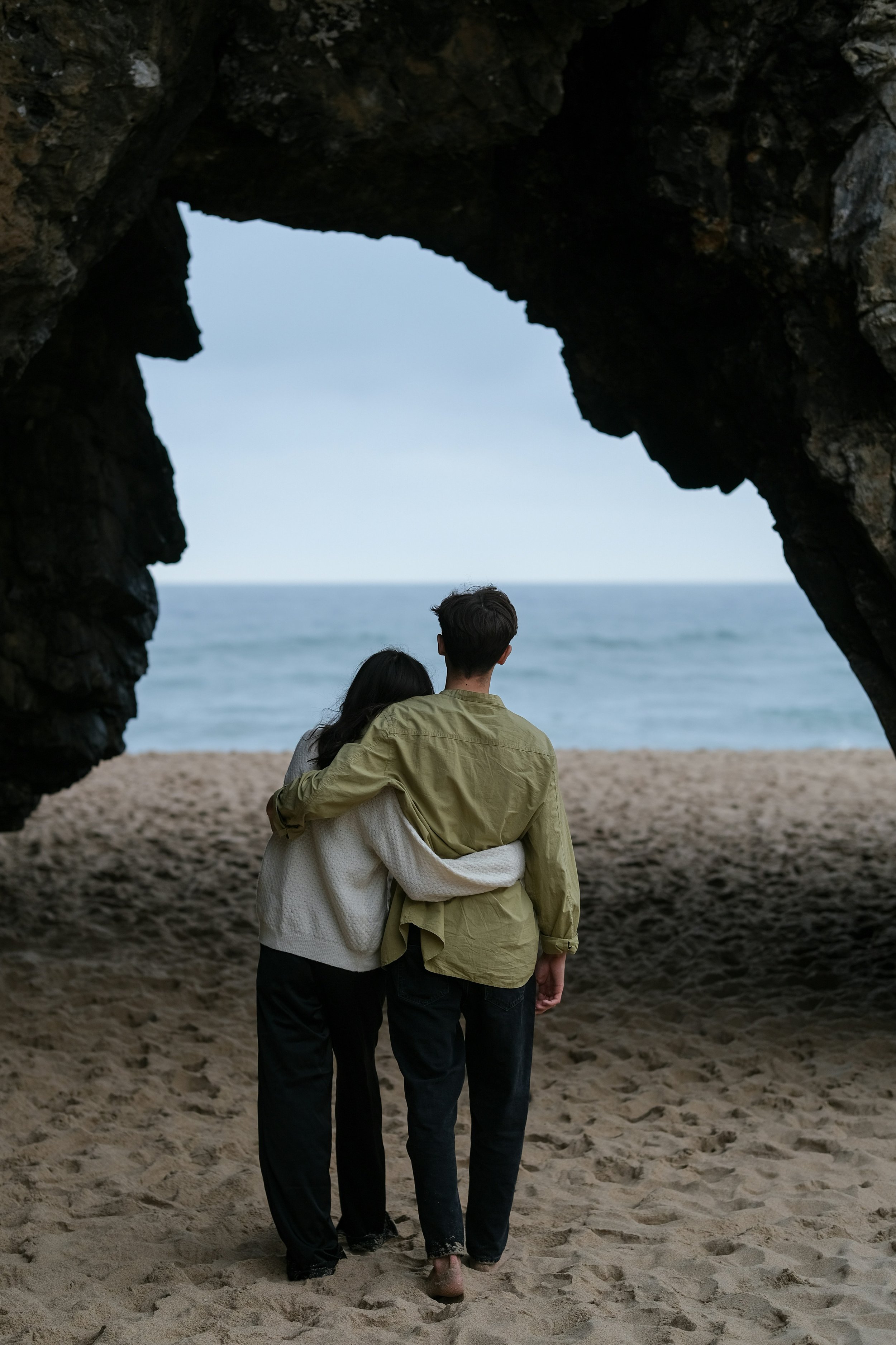 Couple holding each other while looking out to ocean and beach | Stop Diagnosing Your Partner