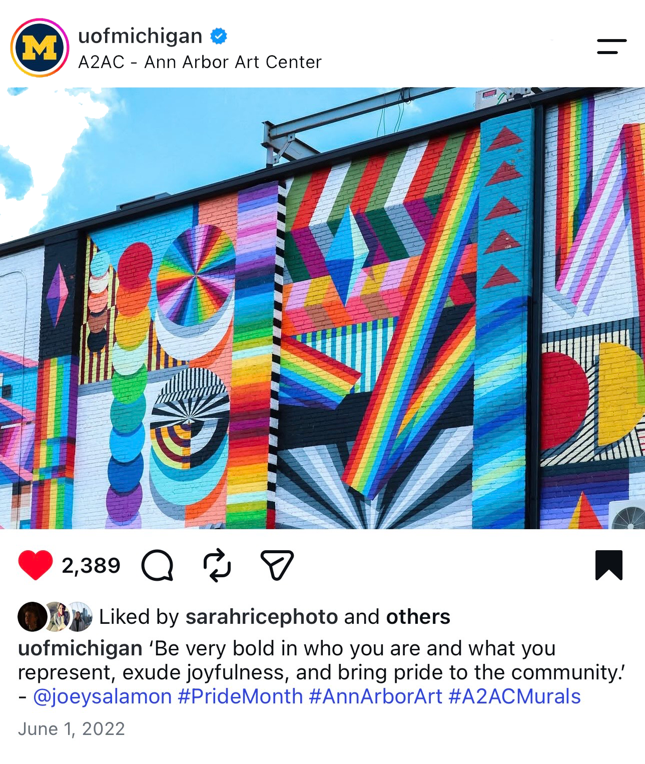Colorful mural painted on the side of a building featuring various geometric shapes, rainbow patterns, and bold lines.