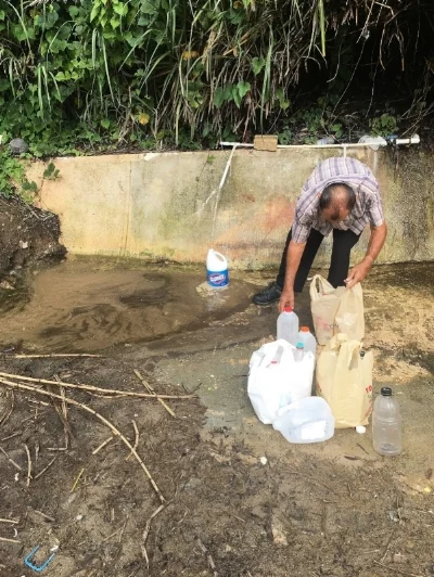 A man collects water after Hurricane Maria cuts water service to his home in Puerto Rico. Photo: David Harvey