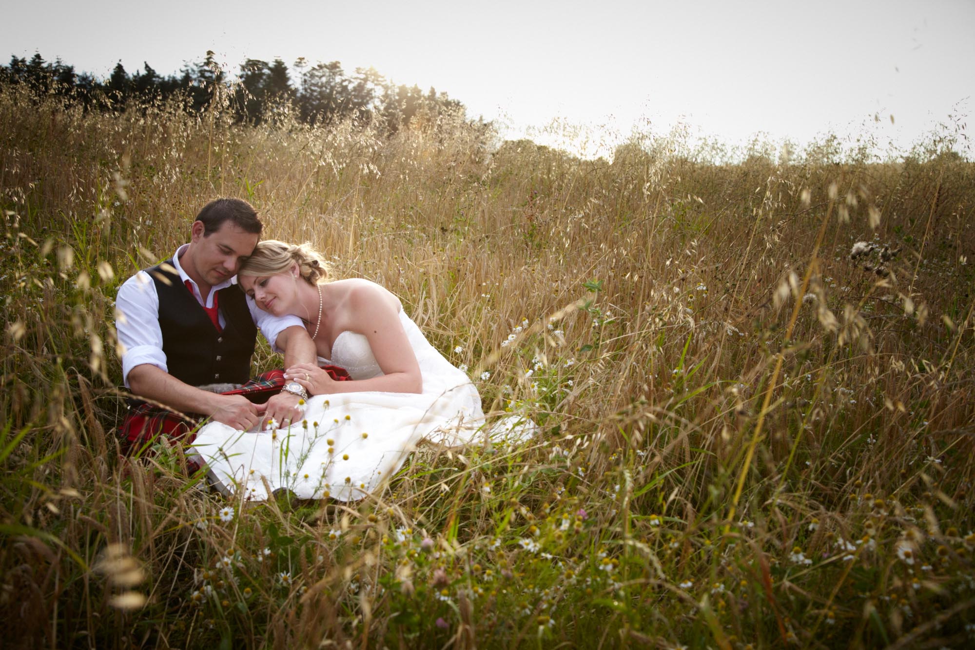 Bride & Groom Sitting in a Field - Romantic Weddings at Huntstile Farm