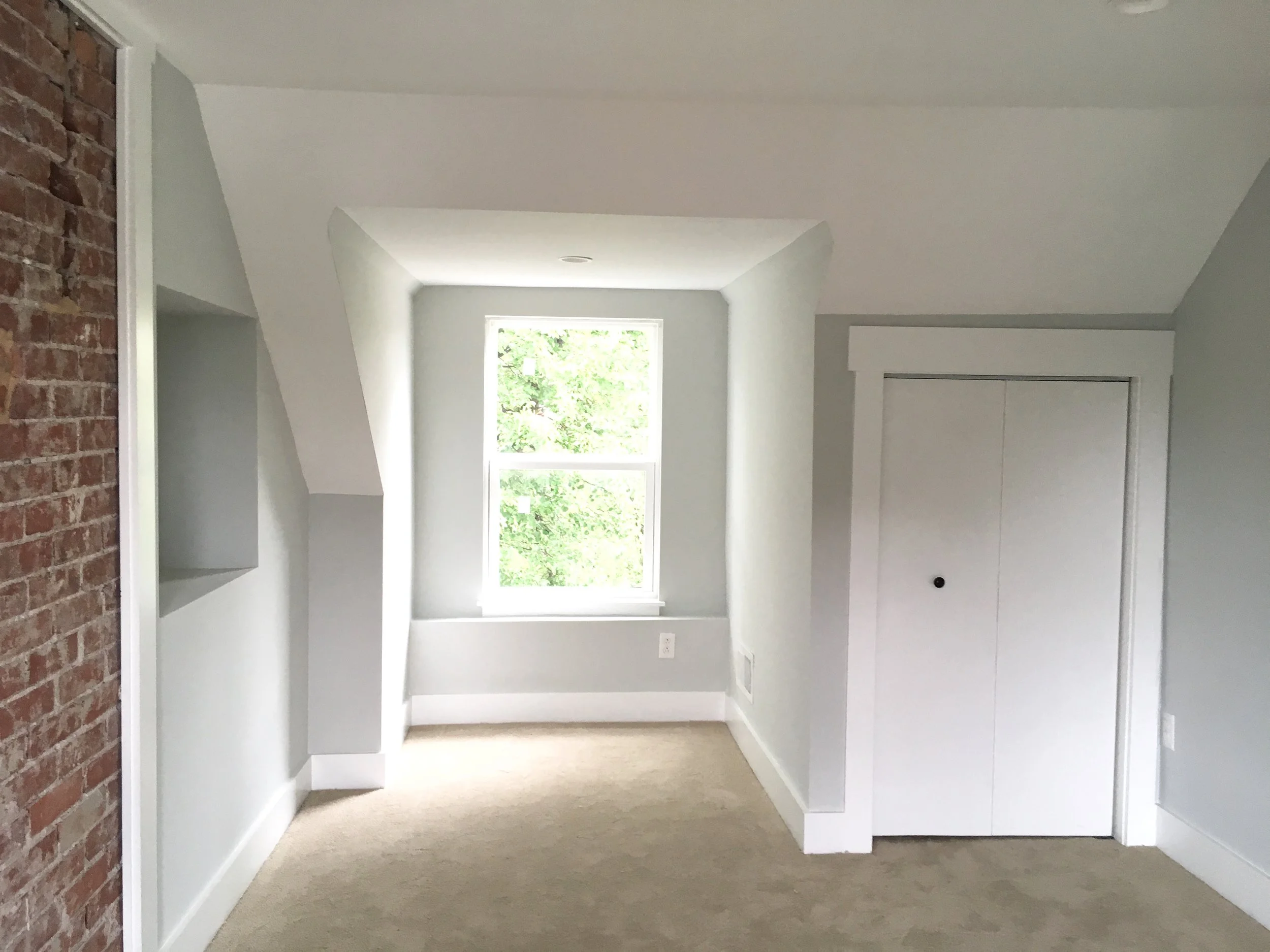 After: since this bedroom is awkwardly shaped, the wall was framed out flush on either side of the fireplace to provide a place for a bed. A new closet is tucked under the sloped ceiling line. 