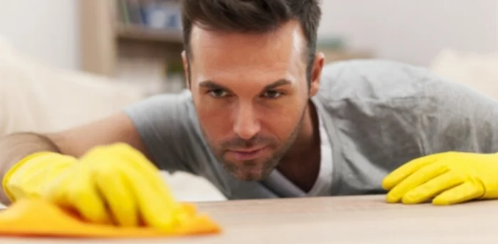 A certified professional cleaning the surface of a table