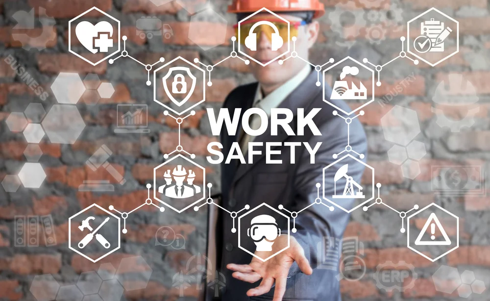 Man with hard hat holding hand under virtual images of work safety