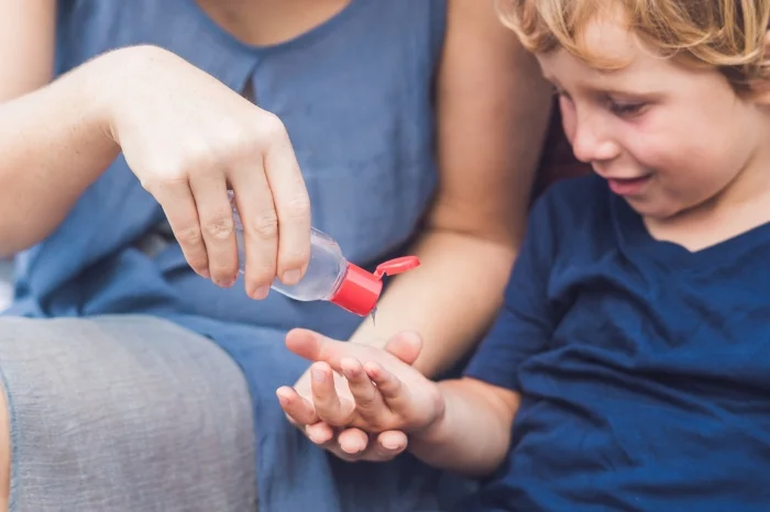 A mother and child sharing hand sanitizer