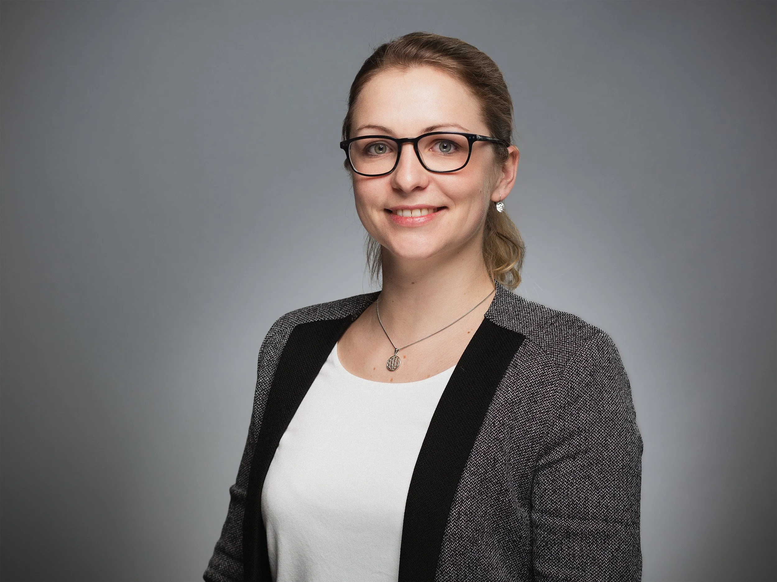 Modernes Business Porträt München, für Webseite, LinkedIn, Social Media, Portrait einer Mitarbeiterin vor neutralem Hintergrund