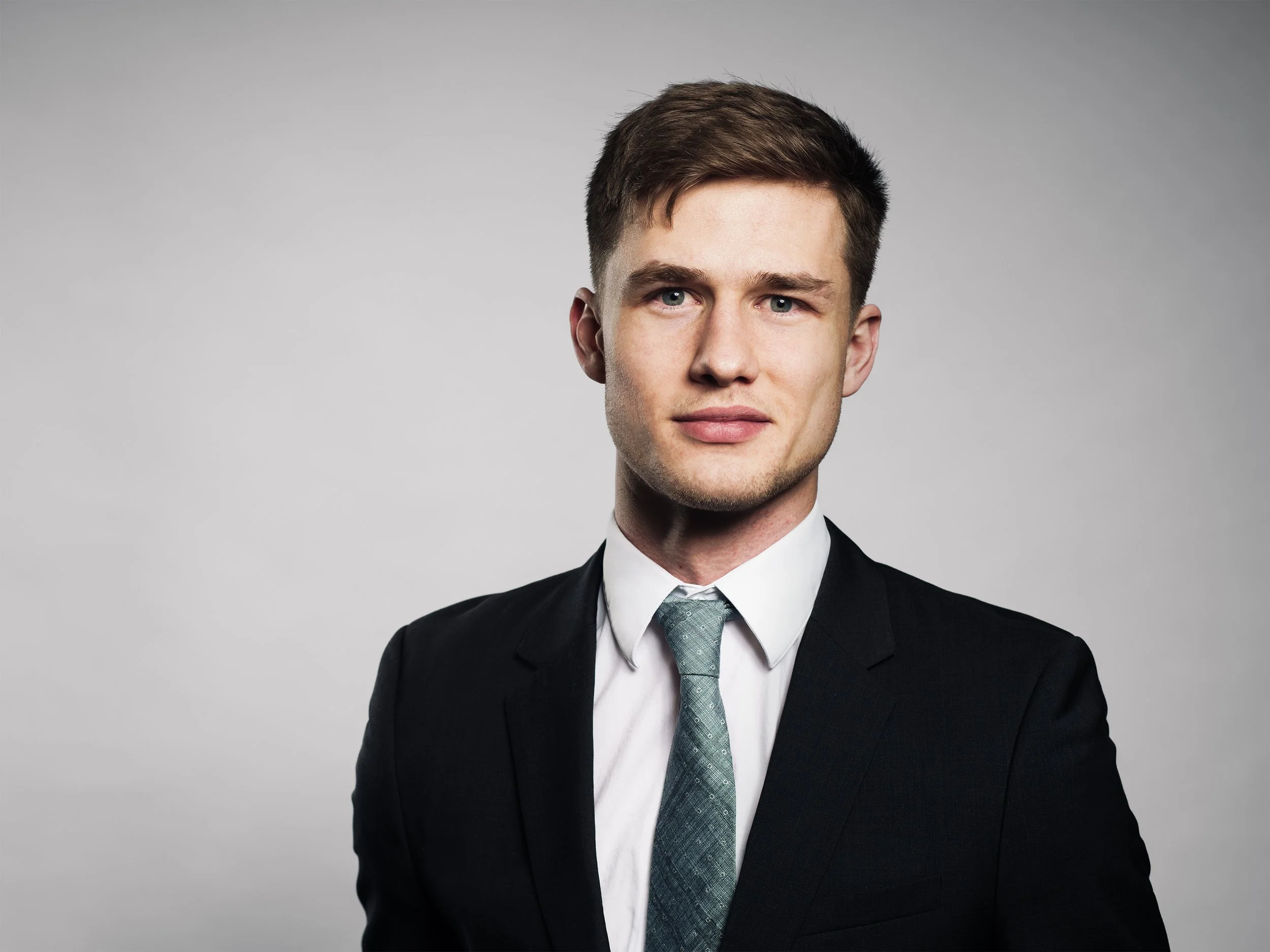 Corporate Portrait München – Mann im Businessanzug, heller Studiohintergrund
