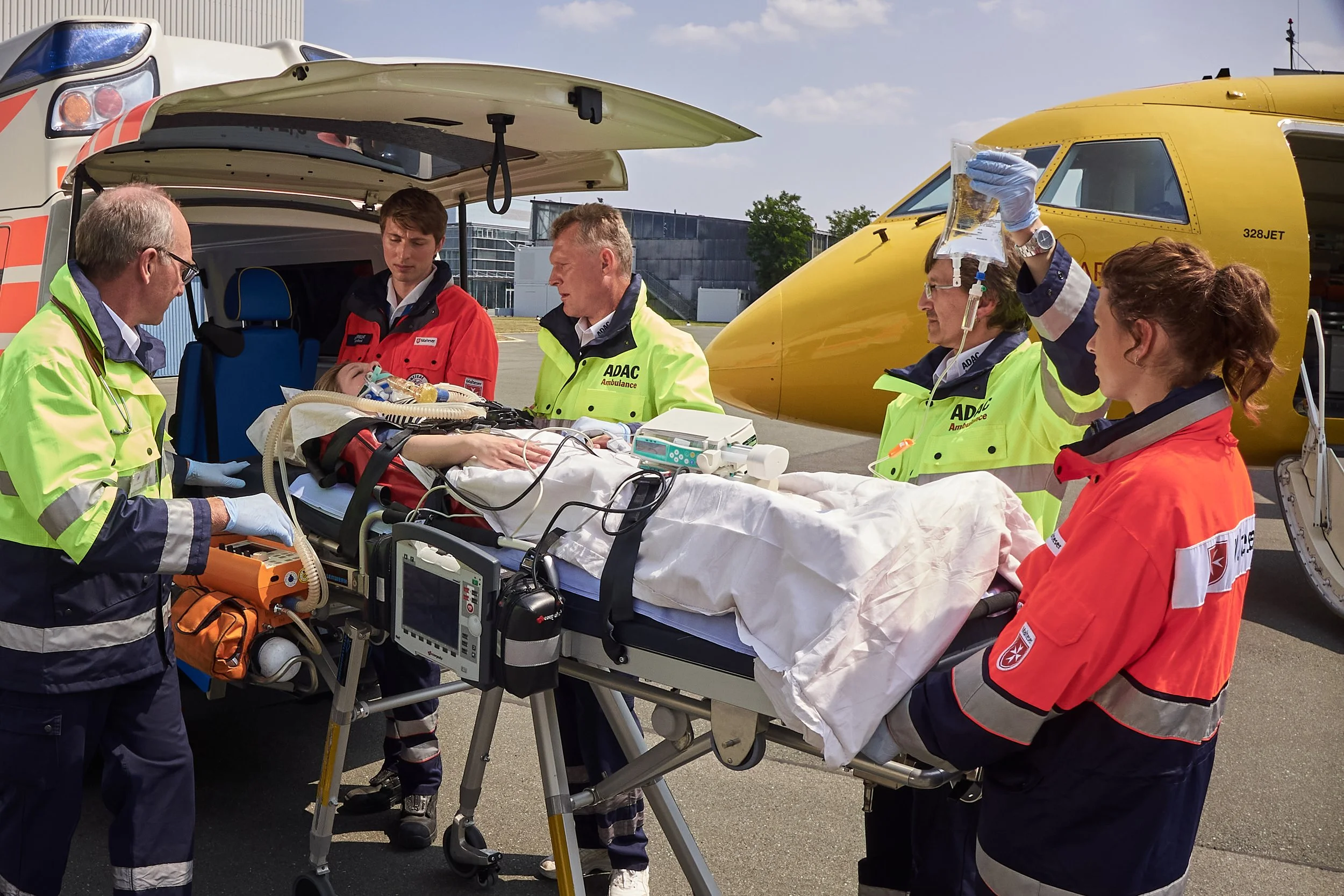 Medizinisches Team versorgt eine verletzte Person auf einer Trage vor einem Hubschrauber im Rettungseinsatz.