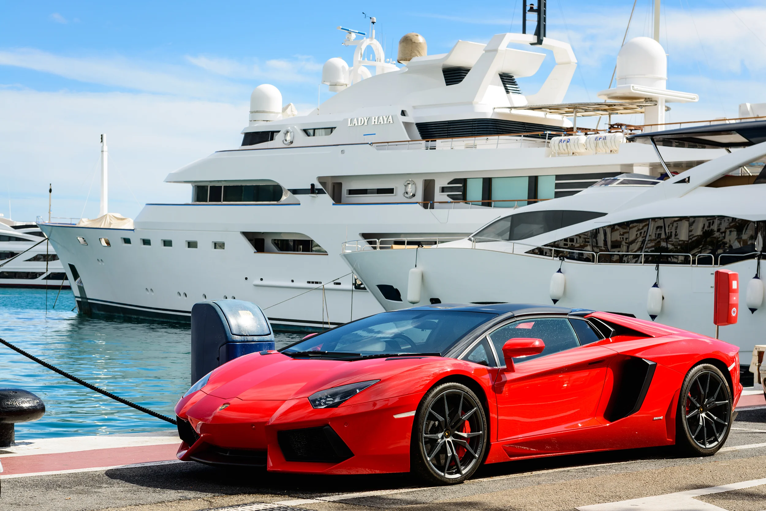 Luxury sports car and yachts at Puerto Banus in Marbella