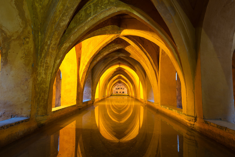 Illuminated ancient baths below the Alcázar