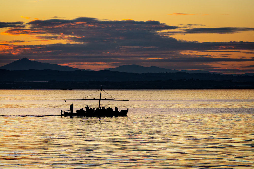 Silhouette of a small traditional boat at dusk in the Albufera in Valencia