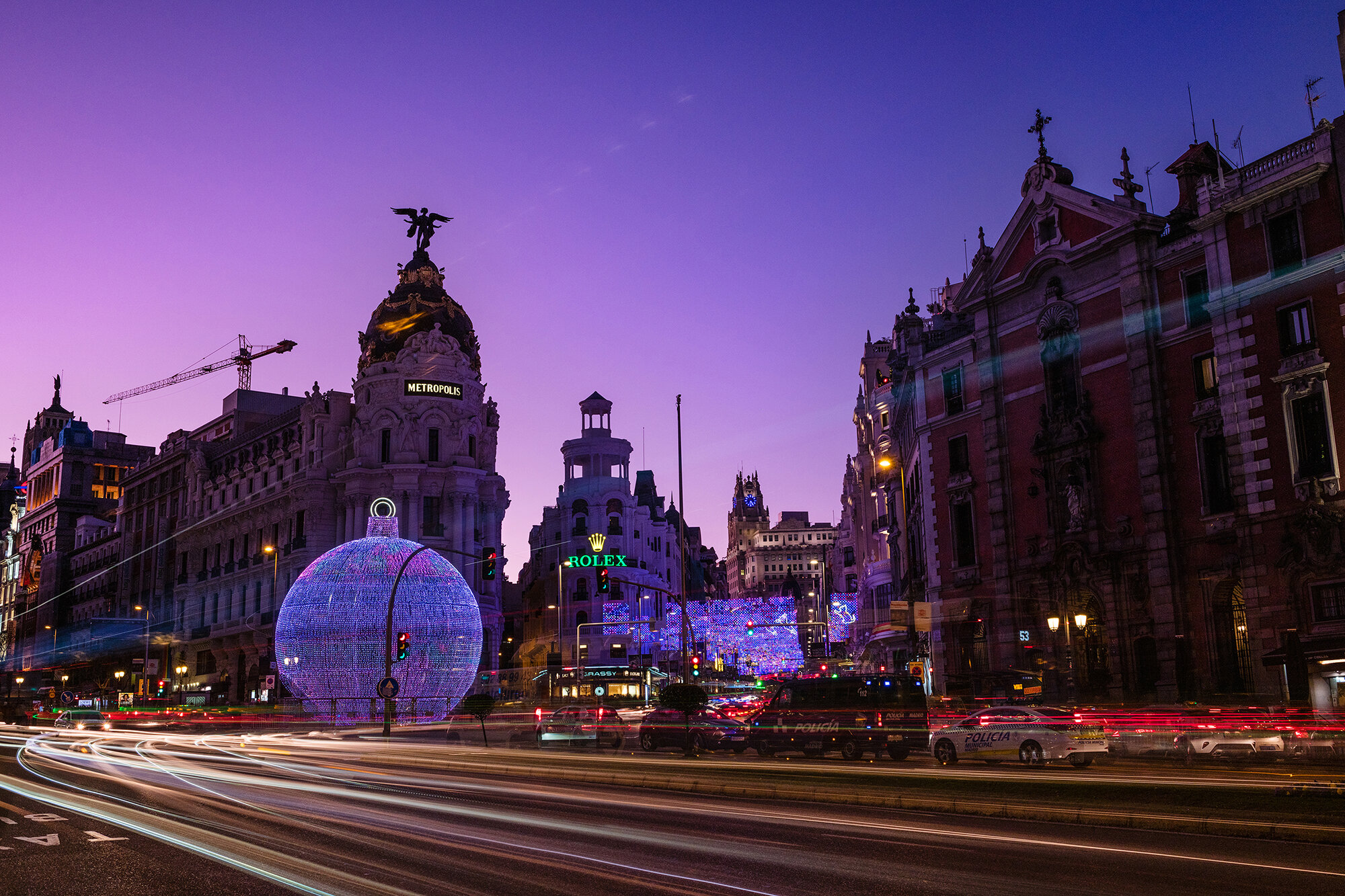 Night view of Madrid Alcala and Gran Via streets illuminated by the traffic and the Christmas decorations.