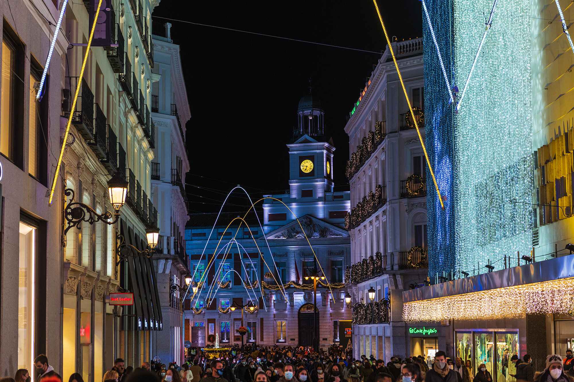 Crowds of people gather at the calle Preciados in Madrid under the Christmas lights.