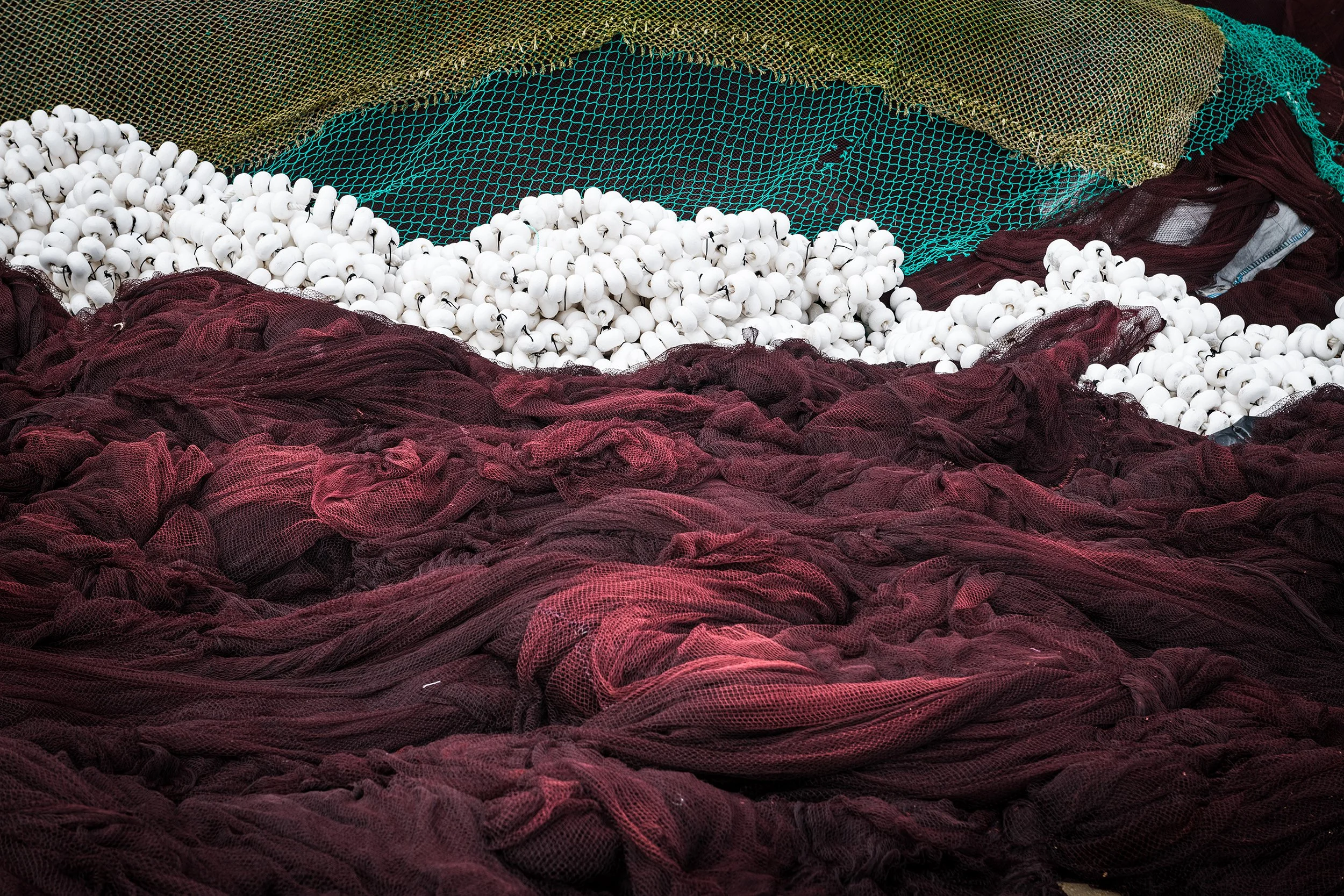 Close-up of green and brown fish nets and traps drying on the Galician coast at dusk, Spain.