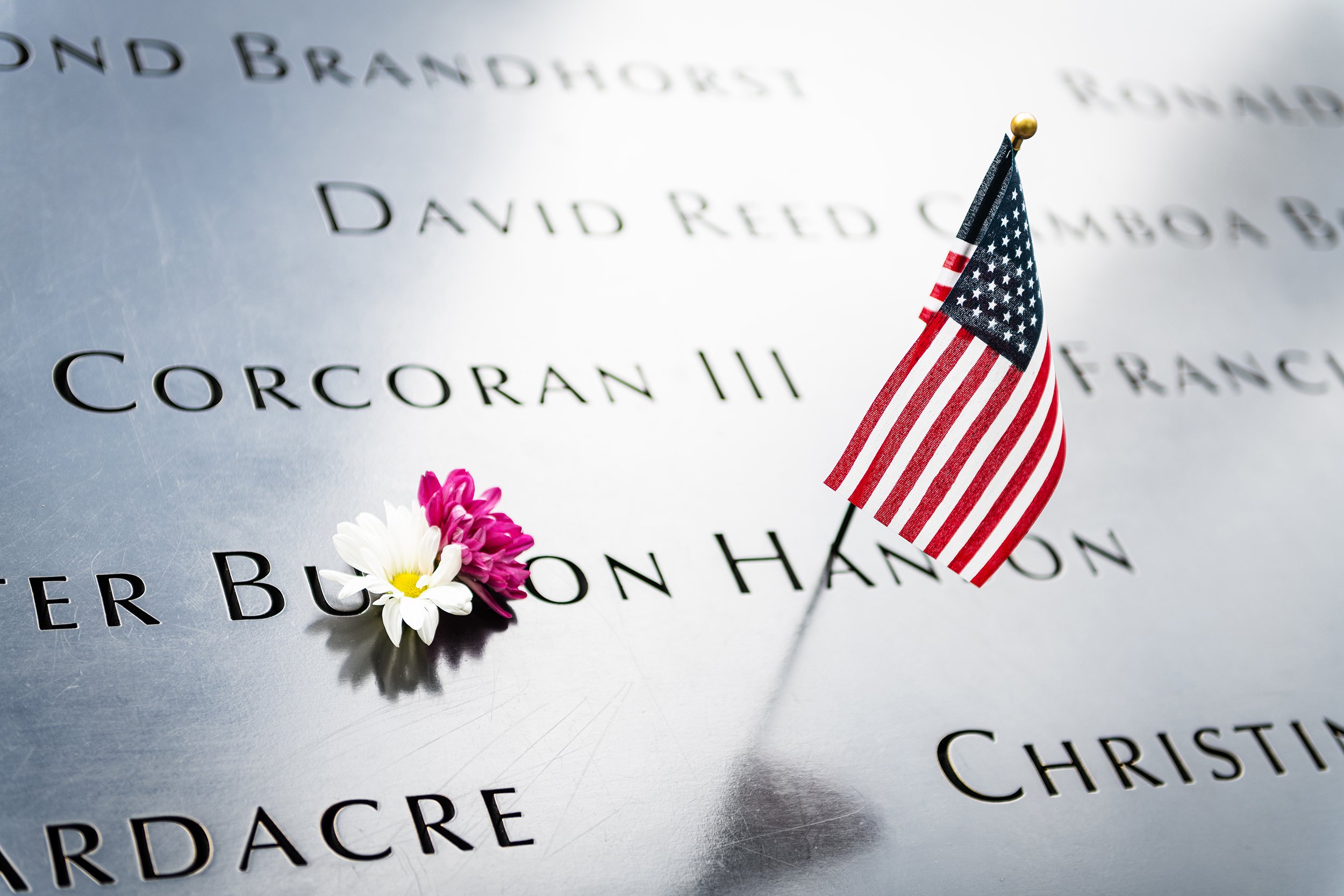American flag and flowers placed at the 9/11 Memorial in Lower Manhattan, New York City
