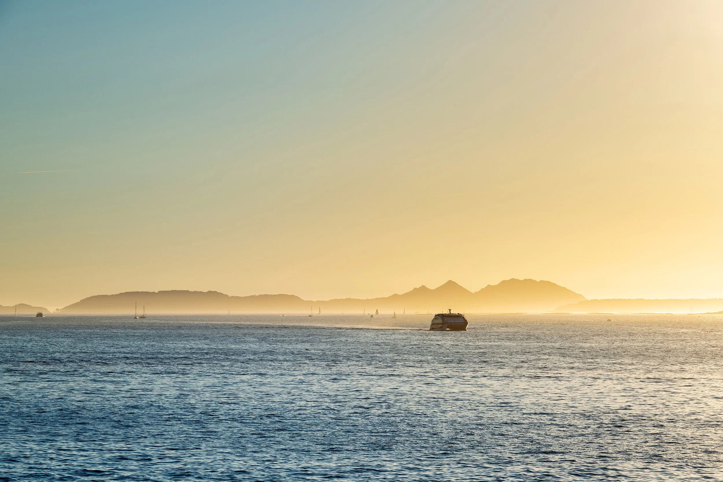 Ferry boat and Cies Islands in Galicia at dusk, Spain