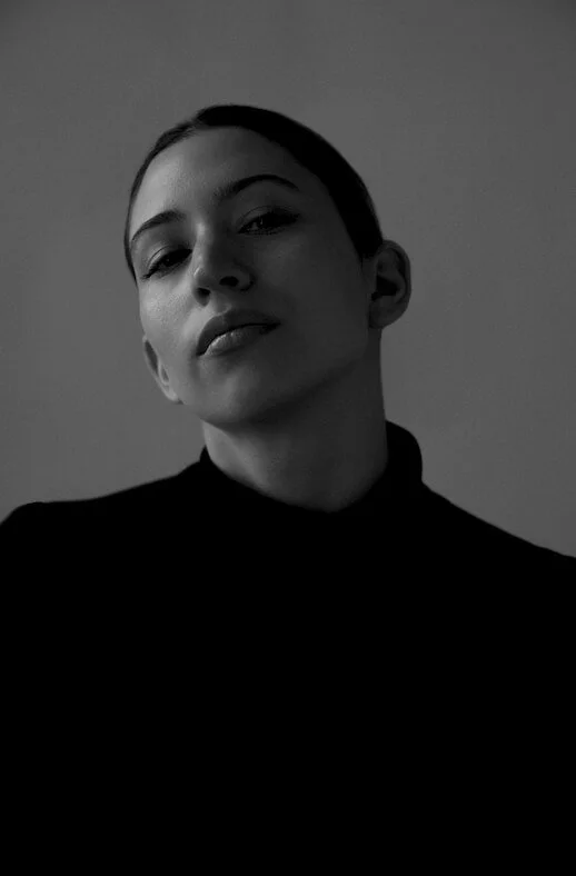 black and white portrait of a young woman in a black turtleneck in a stylish studio photoshoot