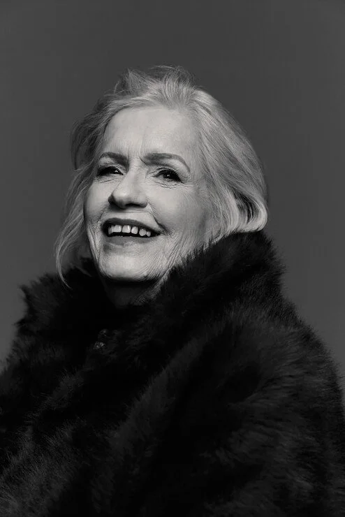 mature woman laughing at the camera in a black and white portrait