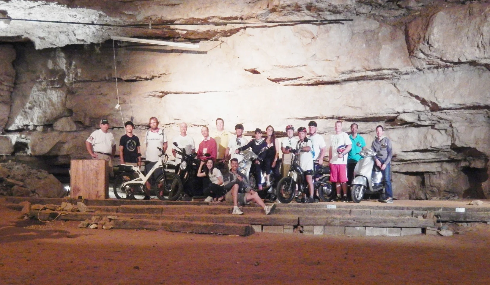 Members of the Ride the Future Tour and their guide pose with their vehicles in the Volcano Room.