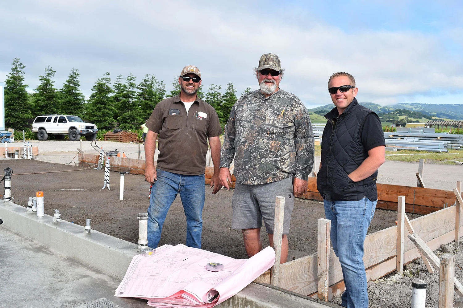 Jared and Joe Lunny of Lunny Engineering review with Brendan Roche the placement of the arriving structural members