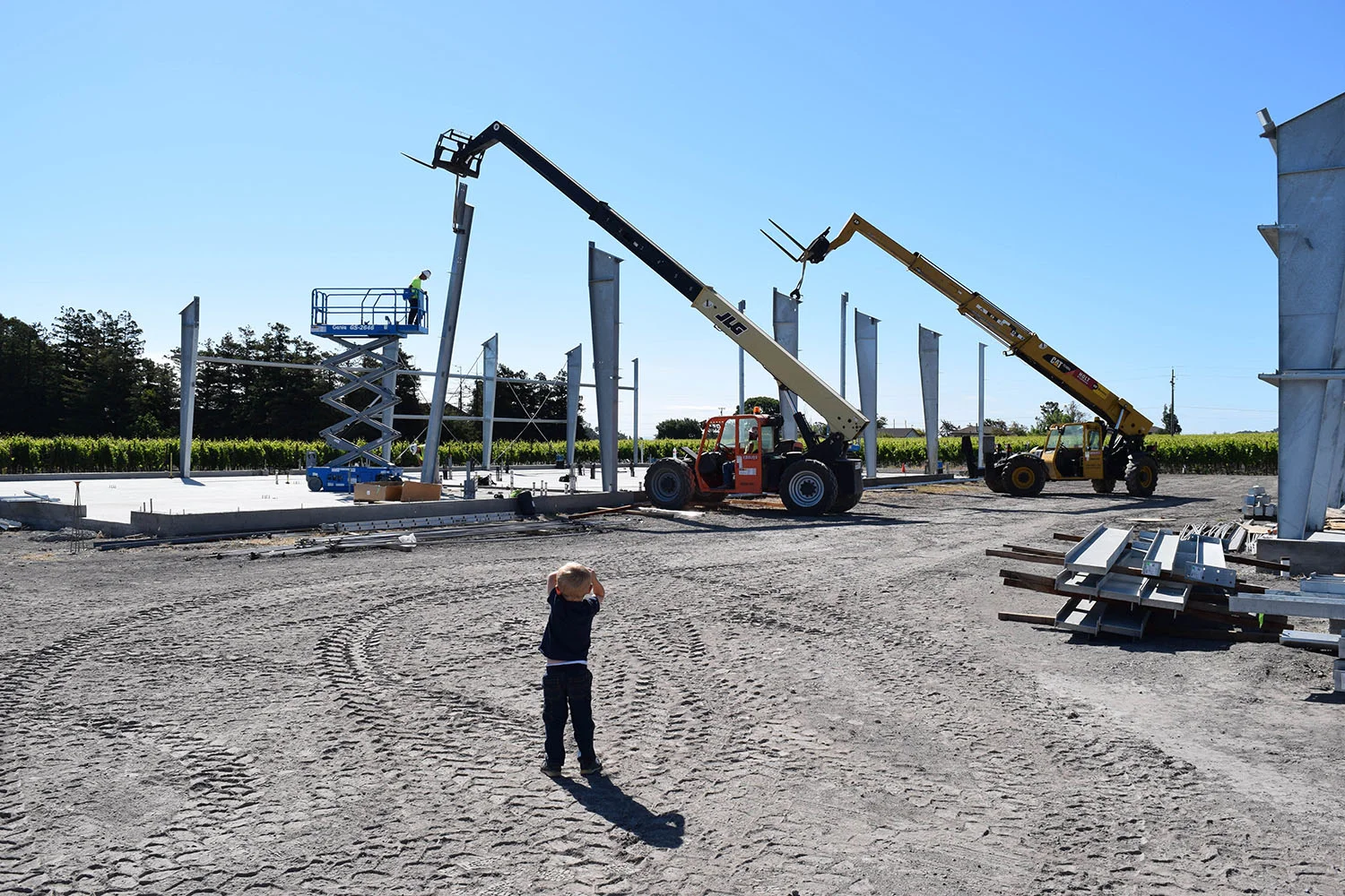 Liam Roche, son of Brendan Roche, looks on in awe of the big machinery used to set the framing in place
