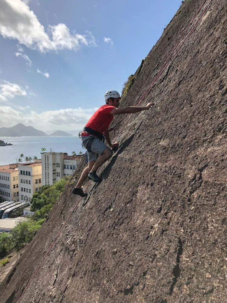 Student climbing during his rock climbing lesson on Morro da Babilonia