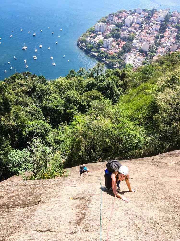 A couple climbing on Morro da Urca during their rock climbing lesson with Rio Mountain Sports