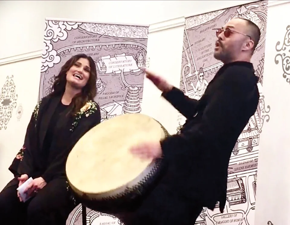 Lien performing at his book launch with Idina Menzel with a map inspired by the SPS grounds in the background.
