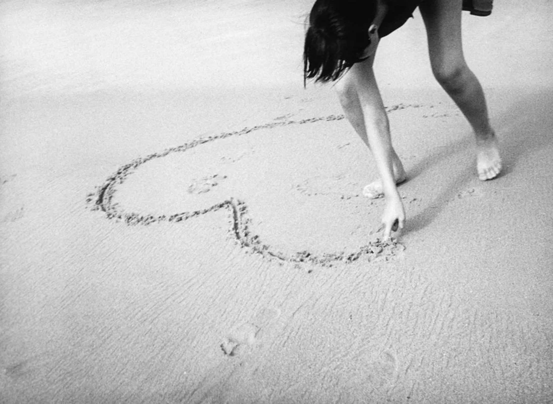 A heart being drawn in the sand – from The Photo-diaries series by Mick Williamson