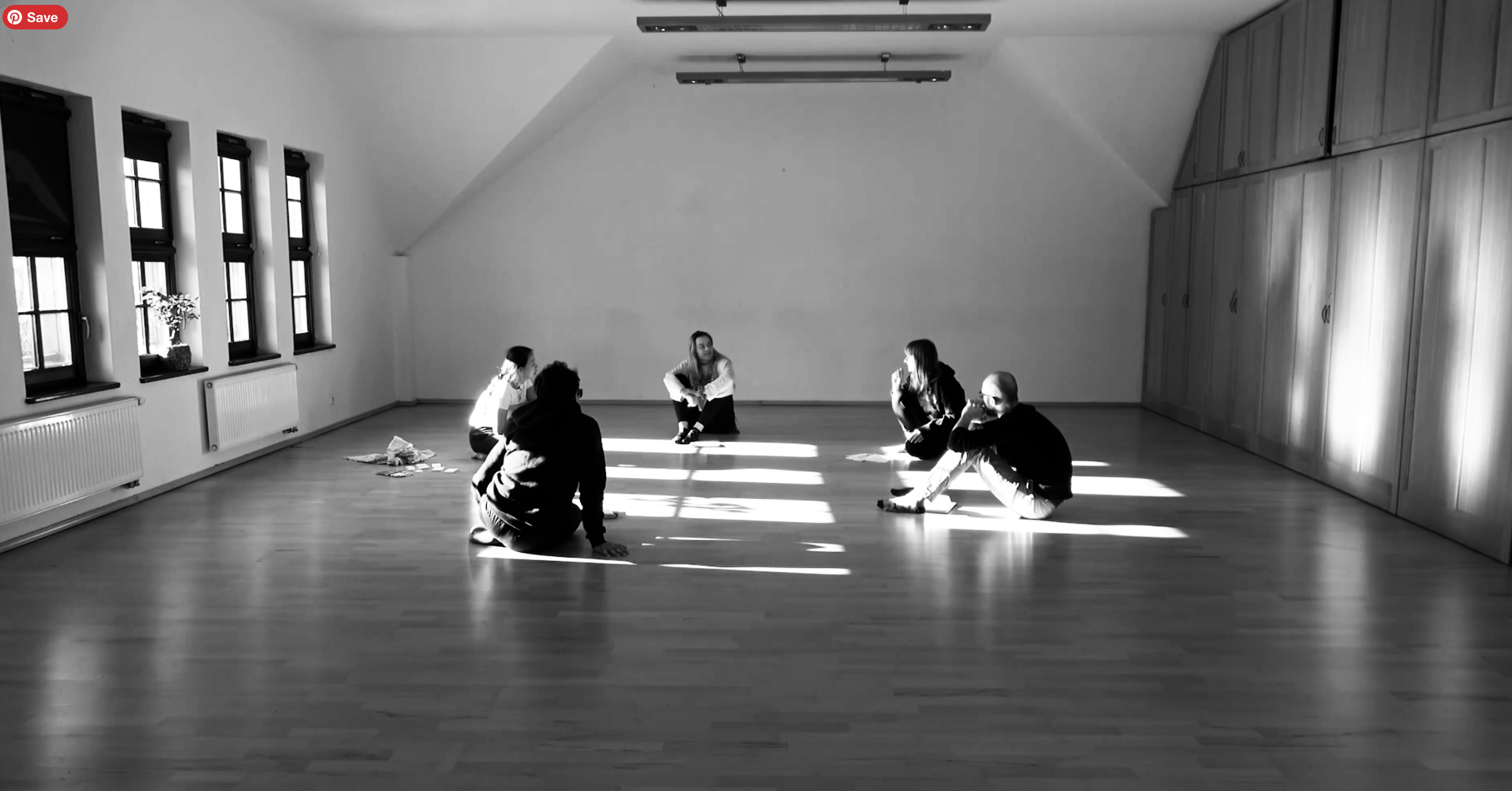    Five people sat on the floor of a studio, having a conversation.   