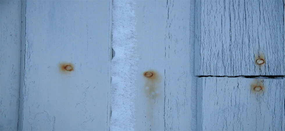 White fence, blue light, rusty nails