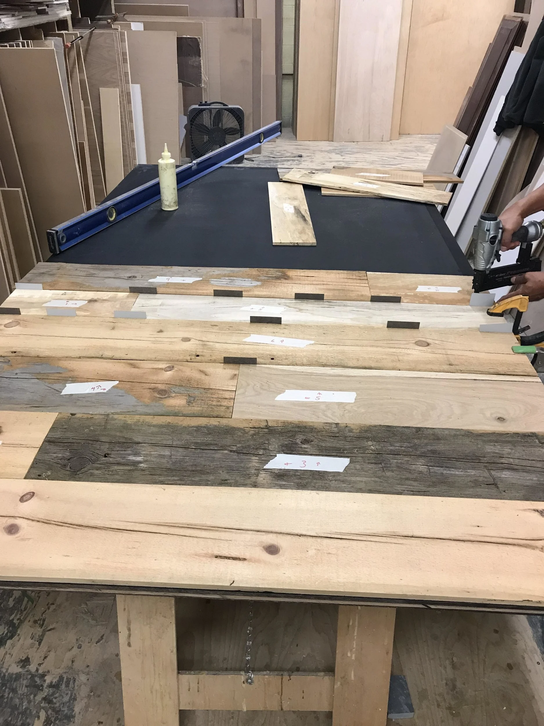 Wood being nailed (with a little glue) to the painted plywood.