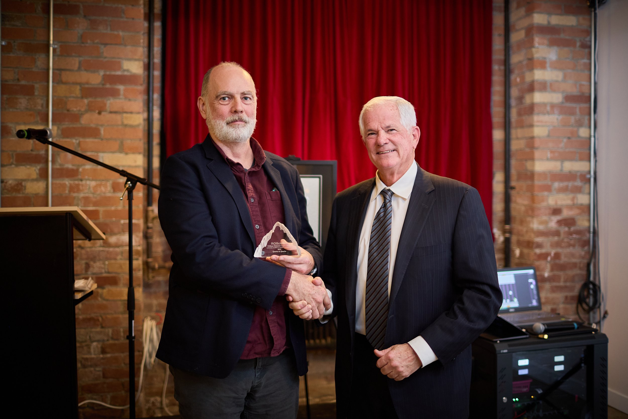  Senior producer Jim Lebans receives the 2023 William Edmond Logan Award on behalf of  Quirks &amp; Quarks  from Jock Fleming 