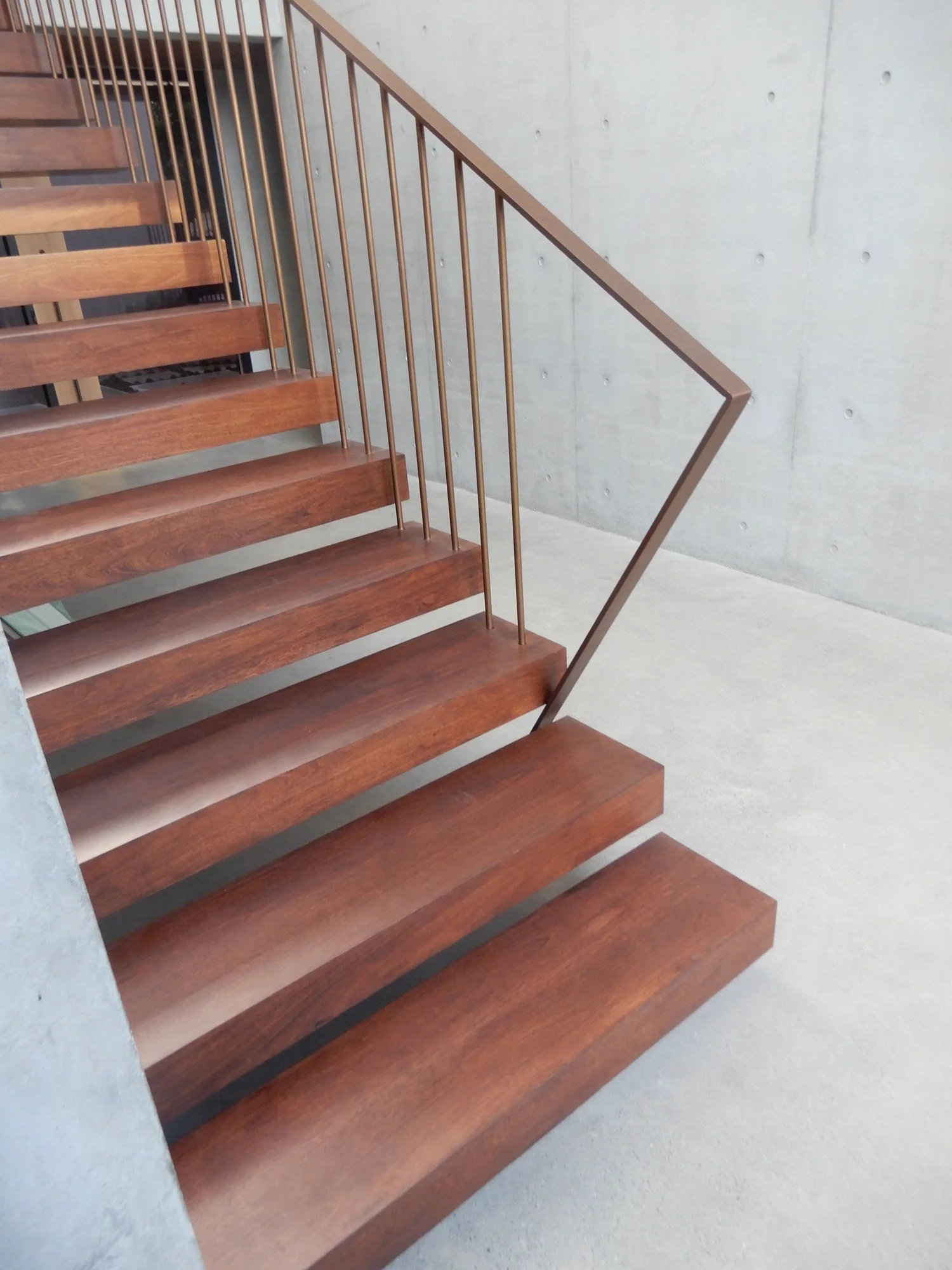 Bronze powder-coated rod balustrade on floating jarrah treads against an off-form concrete wall, Sydney 