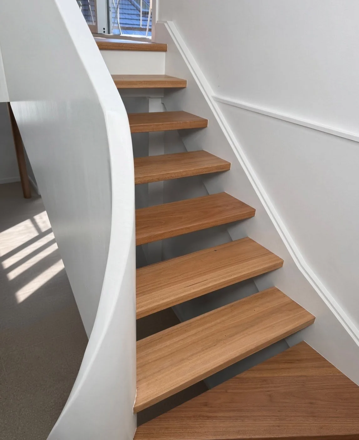  Curved staircase with spotted gum open treads and a smooth white curved stringer, Northern Beaches 