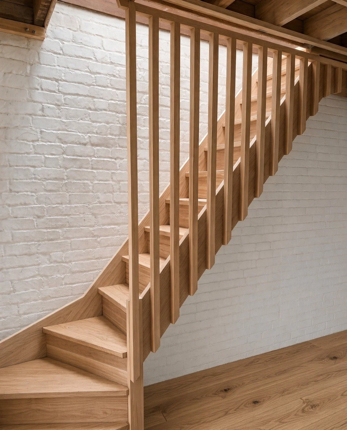  Oak winder staircase with full-height battens against a painted white brick wall, Sydney 