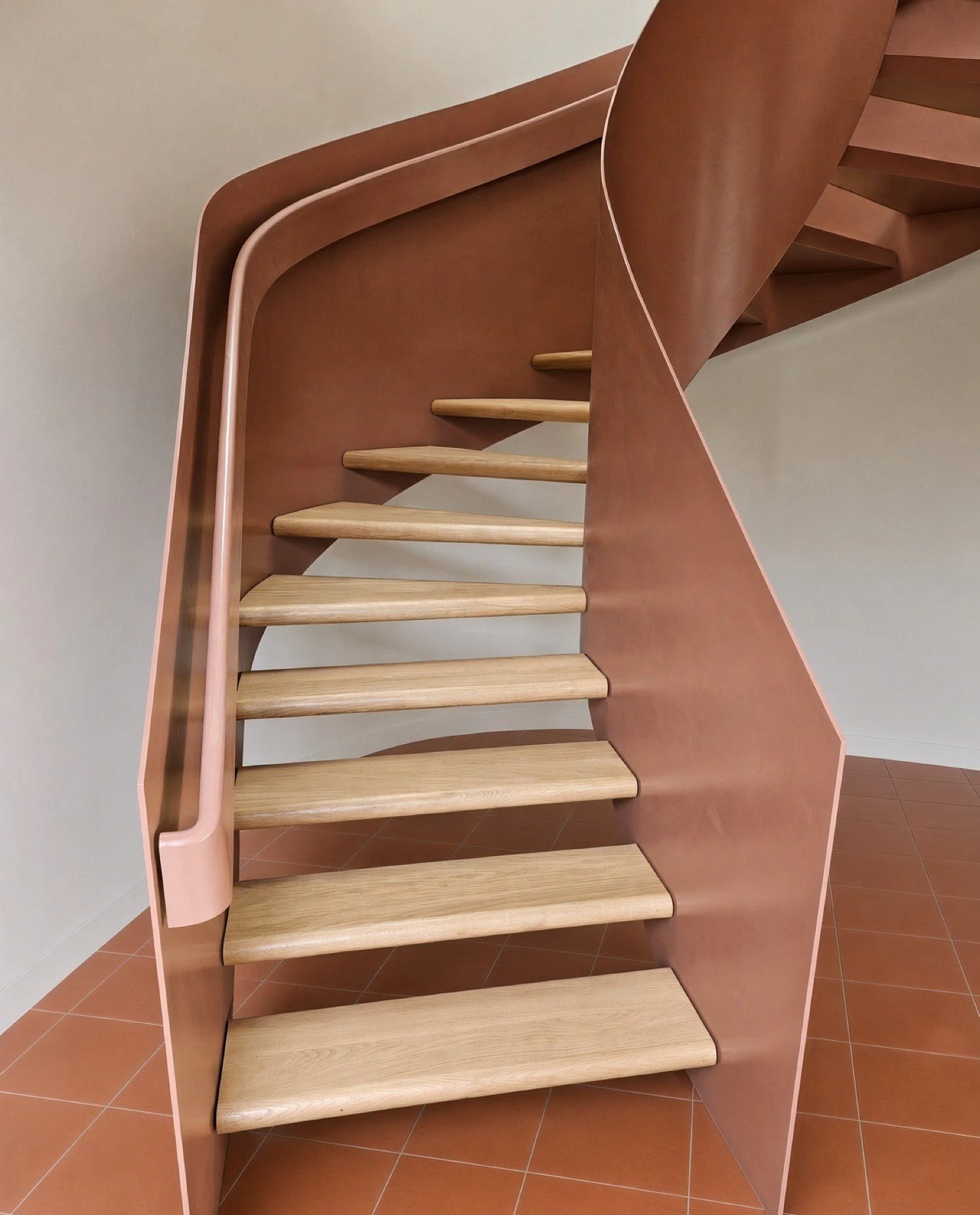 Helical staircase with terracotta-coloured curved stringers and open oak treads, custom built in Sydney 